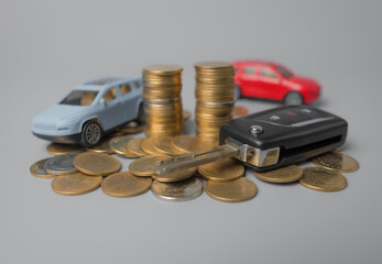 Mini car model and key with stack of golden coins,saving for car,loan and financial concept