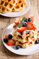 belgian waffles with fresh blueberries, strawberries and sugar.