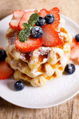 belgian waffles with fresh blueberries, strawberries and sugar.