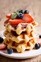belgian waffles with fresh blueberries, strawberries and sugar.