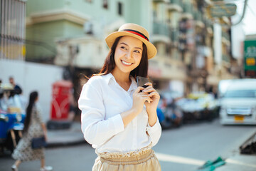 Young stylish woman using phone walking on the street