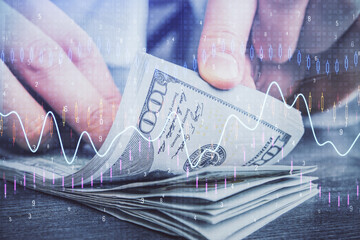 Multi exposure of forex graph drawing hologram and USA dollars bills and man hands. Technical...