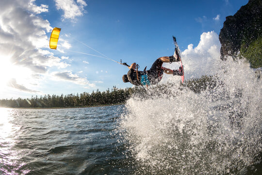professional kiter makes the difficult trick on a beautiful background of spray and beautiful mountains of Mauritius