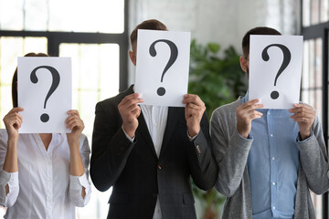 Close up workers hiding faces behind papers with question marks, candidates job applicants standing...
