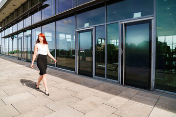Fototapeta na wymiar Young redhead business woman in formal outside