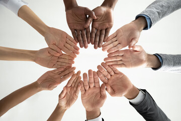 Close up bottom view diverse business people holding hands in circle, engaged in team building...