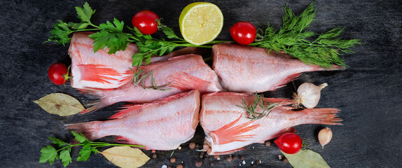 Raw redfish carcasses among the spices and greens