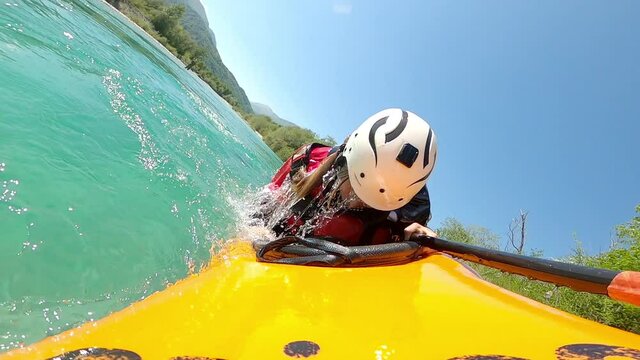 POV slow motion girl kayaking down the river doing eskimo roll