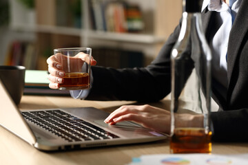 Entrepreneur hands drinking alcohol working on laptop at homeoffice