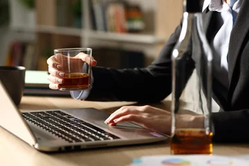 Poster Entrepreneur hands drinking alcohol working on laptop at homeoffice © PheelingsMedia