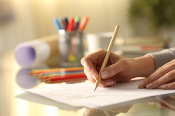 Fototapeta na wymiar Designer woman sketching drawing with pencil on desk