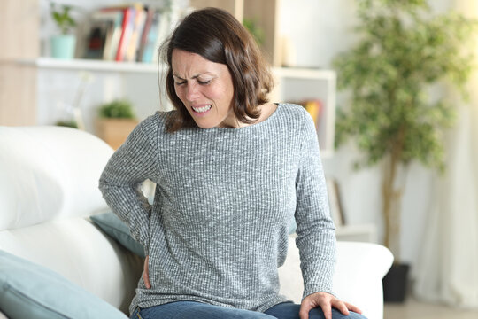 Middle age woman suffering backache at home