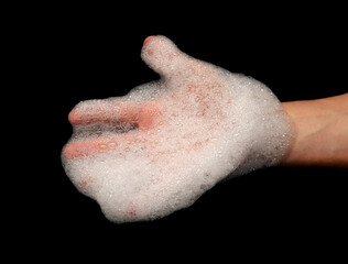 hands in white foam from soap on a black background