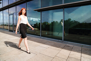 Naklejka premium Young redhead business woman in formal outside