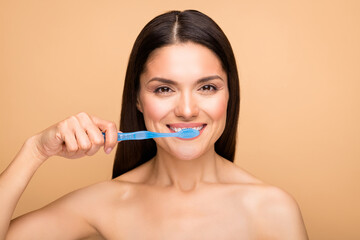 Close up photo of attractive latin naked lady holding blue tooth brush cleaning white teeth use new menthol paste isolated beige pastel color background