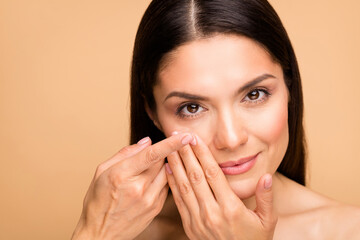 Closeup photo of mature nude lady model natural beauty no makeup holding finger new contact lens...