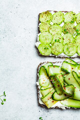 Cucumber and cream cheese toast on white plate, top view. Healthy vegetarian diet concept.