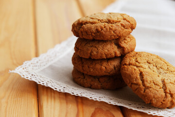 homemade oatmeal cookies tied with thread on a natural linen napkin with lace. It lies on a light wooden background