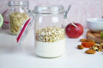 Healthy breakfast overnight oats with fresh berries in a glass jar with dried fruits, apple and nuts, walnuts, almonds. with yogurt, cottage cheese, pudding. diet, keto diet