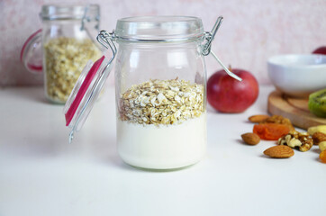 Healthy breakfast overnight oats with fresh berries in a glass jar with dried fruits, apple and nuts, walnuts, almonds. with yogurt, cottage cheese, pudding. diet, keto diet