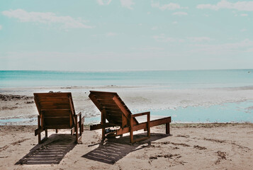 Fototapeta na wymiar wooden deck chairs on the beach on a Sunny day