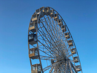Silver metal ferris wheel in the park across blue sky. Background. Copy space. Summer concept....