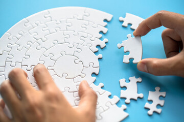 Businessman hand connecting jigsaw puzzle, Business solutions,  target, success, goals and strategy concepts