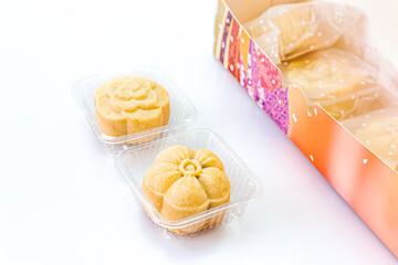 Two piece of delicious pineapple bread near the colorful box on a white background. Copy space, Selective focus.