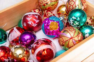 Fototapeta na wymiar many multicolored glass Christmas balls in a box