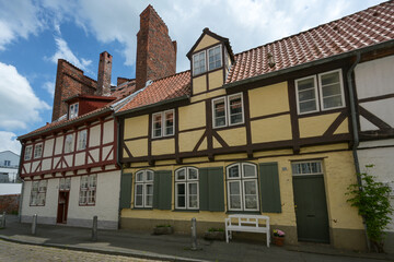 Half-timbered houses added to the former city wall and the half tower from the 13th century in the old town of the hanseatic city Luebeck, Germany, blue sky with clouds