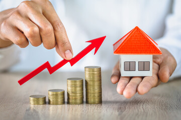 businessman holding a graph on a pile of coins, The concept of real estate market growth. coins...