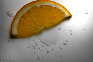 orange slice on white background with water drops
