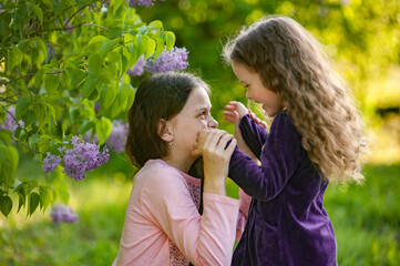 Obraz premium Two sisters play together outside the house in nature.