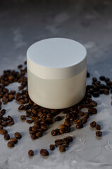 cosmetic jar with coffee beans on background