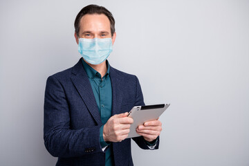 Portrait of his he business manager guy holding in hands ebook browsing reading corporate report recommendation tips wearing gauze mask isolated on gray light pastel color background