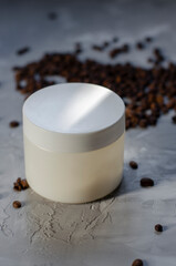 cosmetic jar with coffee beans on background