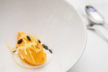 Fresh mango ice cream sorbet with pumkin seeds in white bowl