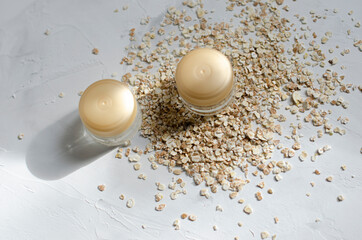 jars for cosmetics on a white background with wheat and oatmeal