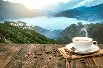 Morning cup of coffee and coffee beans with mountain background at sunrise. Beauty mountain...