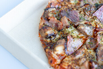 Homemade barbecue chicken and bacon pizza in food delivery paper box.