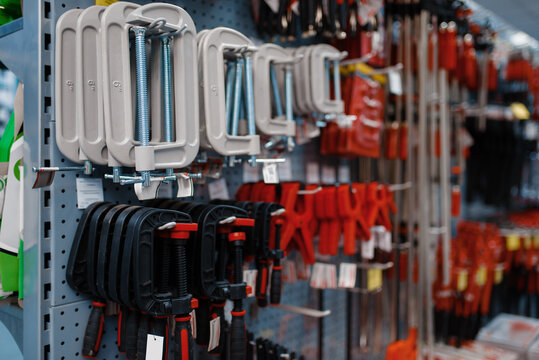 Vise and clamps on racks in tool store closeup