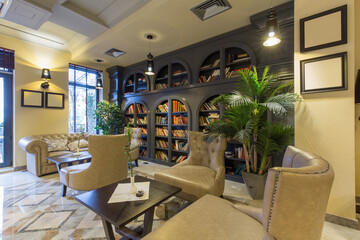 Obraz premium Interior of a hotel lounge with leather furniture and bookshelf
