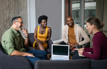 Smiling group of diverse businesspeople talking together during