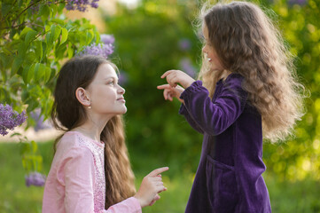 Obraz premium Two sisters play together outside the house in nature.