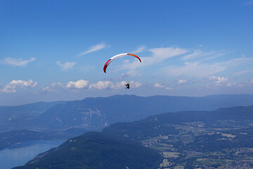 Paragliding active summer sport flying into blue sky of alps mountains 