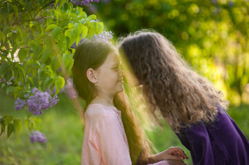 Two sisters play together outside the house in nature.