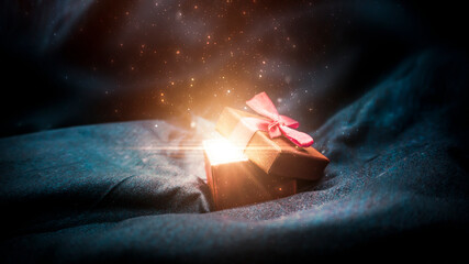 Gift box on a dark magic background with light bokeh. Festive background, magic box with a gift....