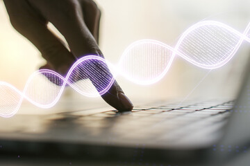 Creative concept with DNA symbol illustration and hands typing on laptop on background. Genome...