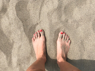 Two female feet on sand close-up. Vacation concept. Copy space. 
