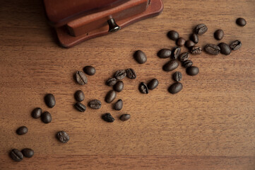 Obraz na płótnie Canvas Vintage coffee grinder and coffee beans on brown background
